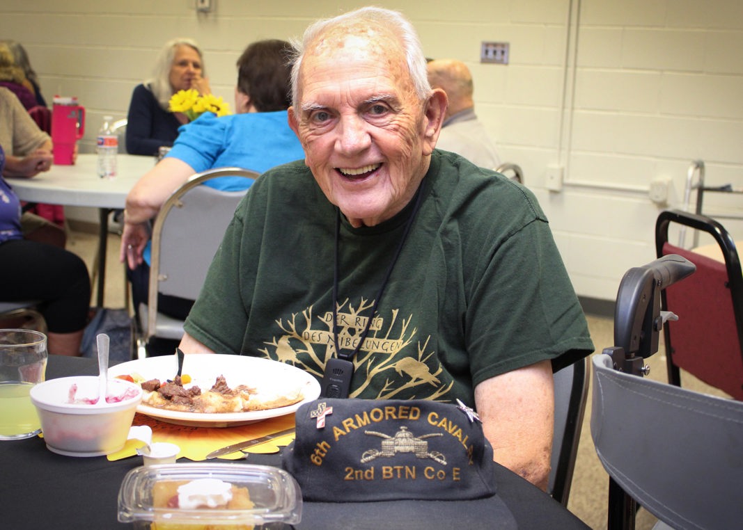 Senior smiling at the Fremont Senior Center as he eats lunch at the table