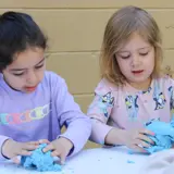 Two children playing with clay in classroom