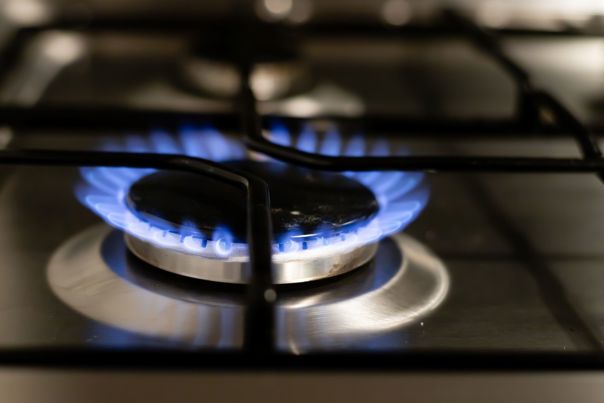 Gas burner lit on the top of a stove.