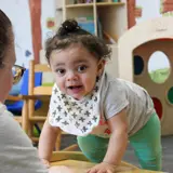 Infant learning to crawl in classroom