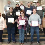 Ten students hold certificates for welding graduation